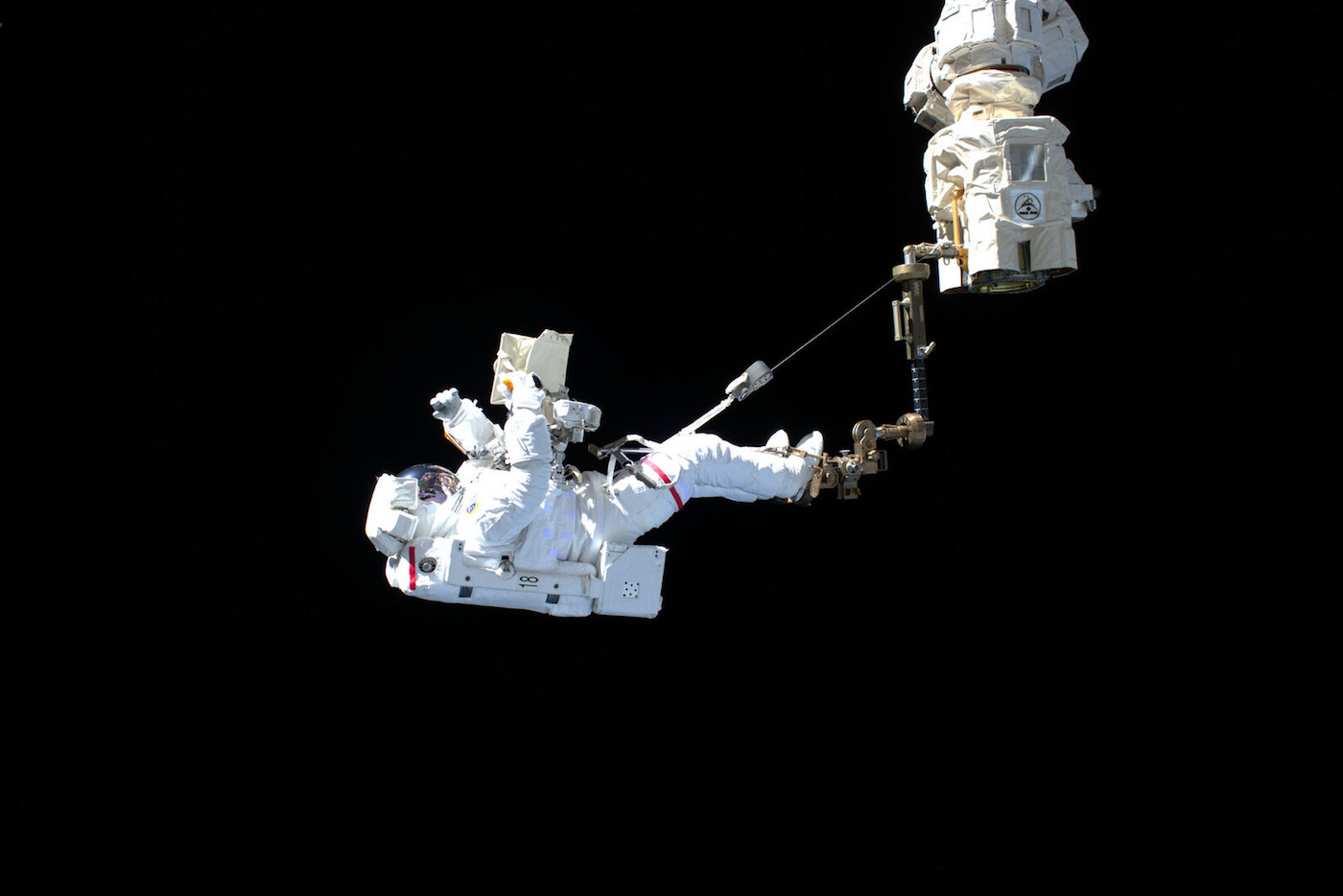 ESA astronaut Luca Parmitano imaged during the first spacewalk for AMS hitching a ride on the International Space Station’s 16-metre long robotic arm. 