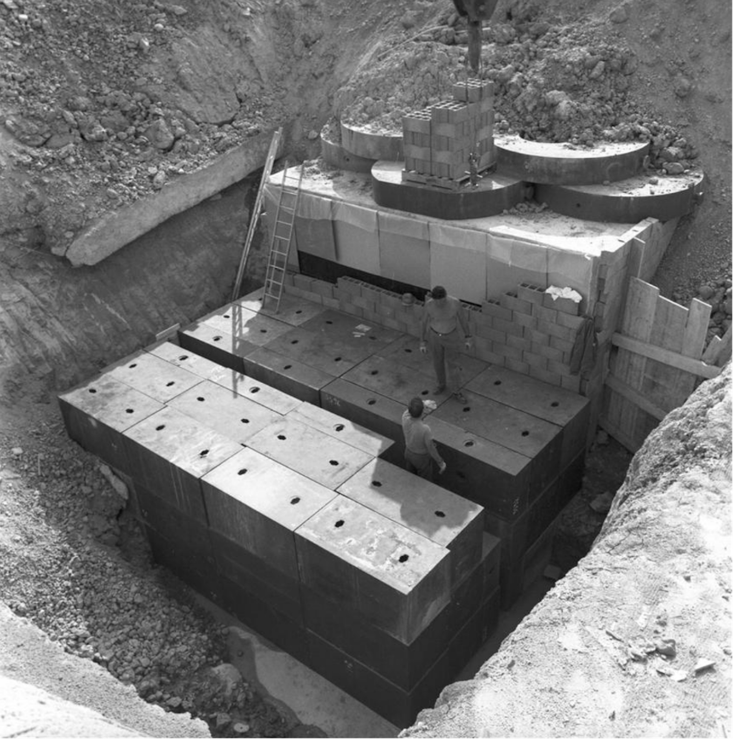 Two men on a cast-iron blocks assembly