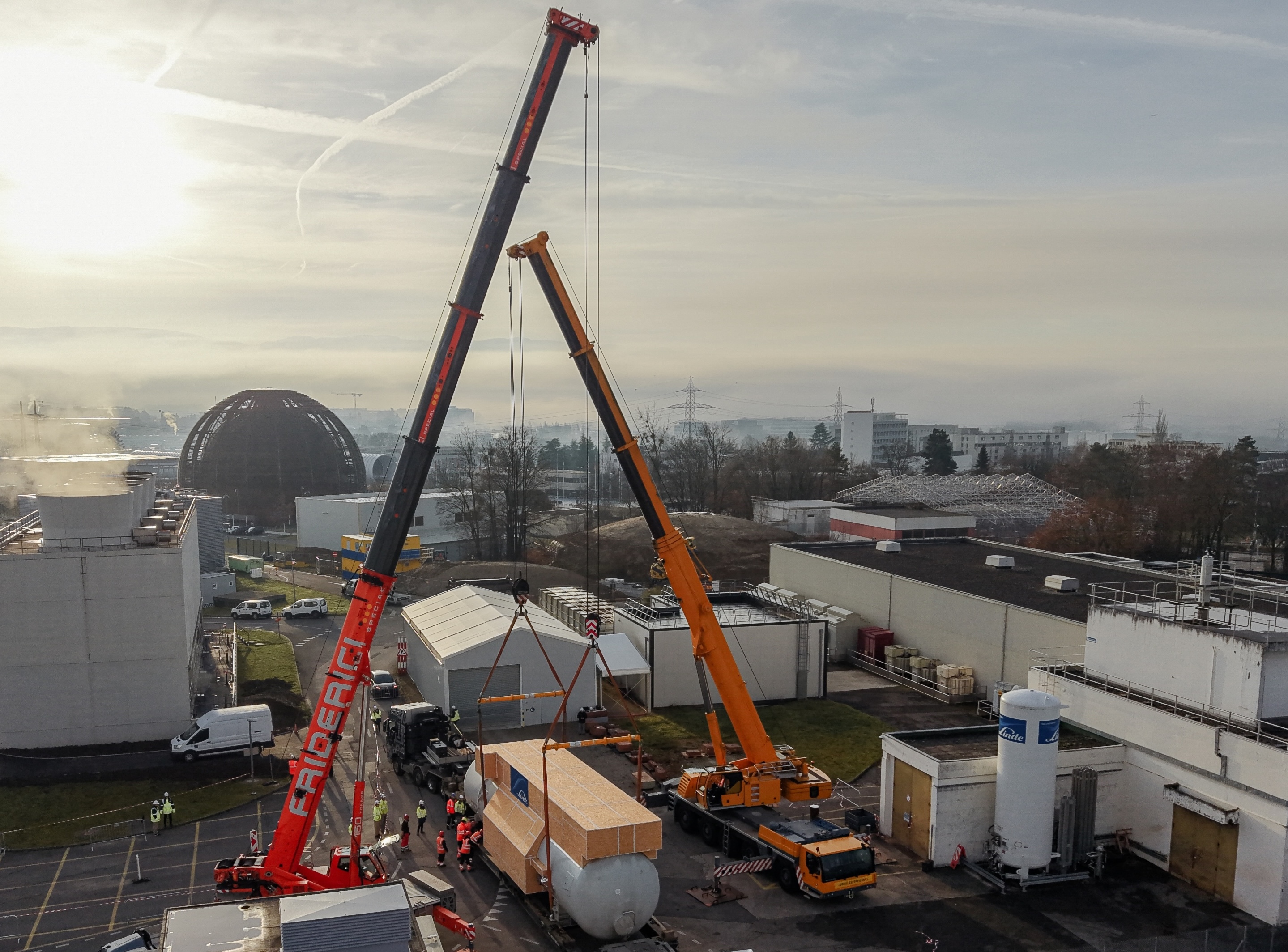 General view of CERN at point 1 with two cranes levering a very big tank