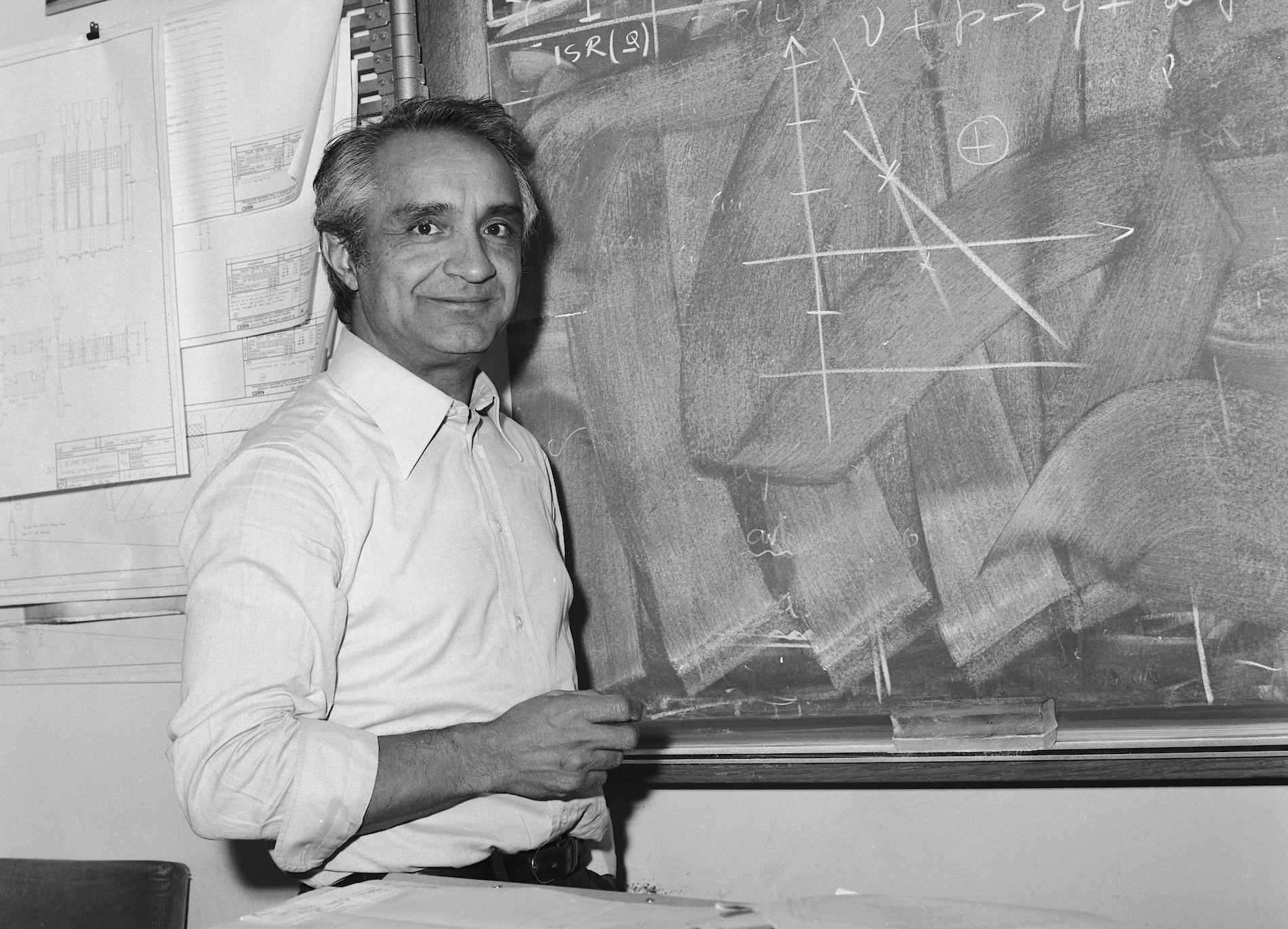 Physicist Antonino Zichichi in front of a black board in 1977