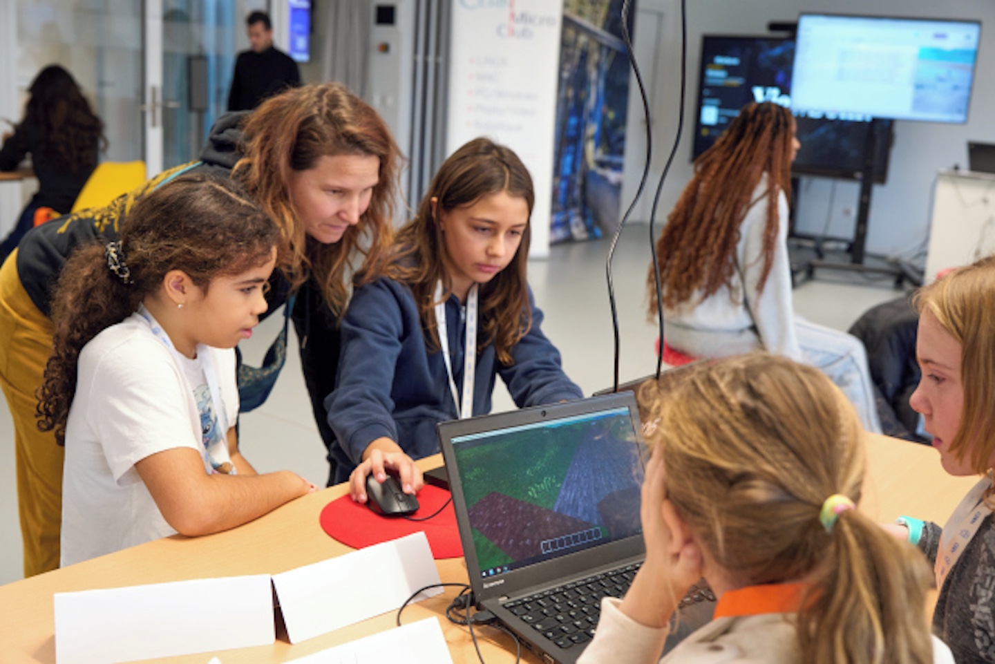 Woman scientist with girls working on computers