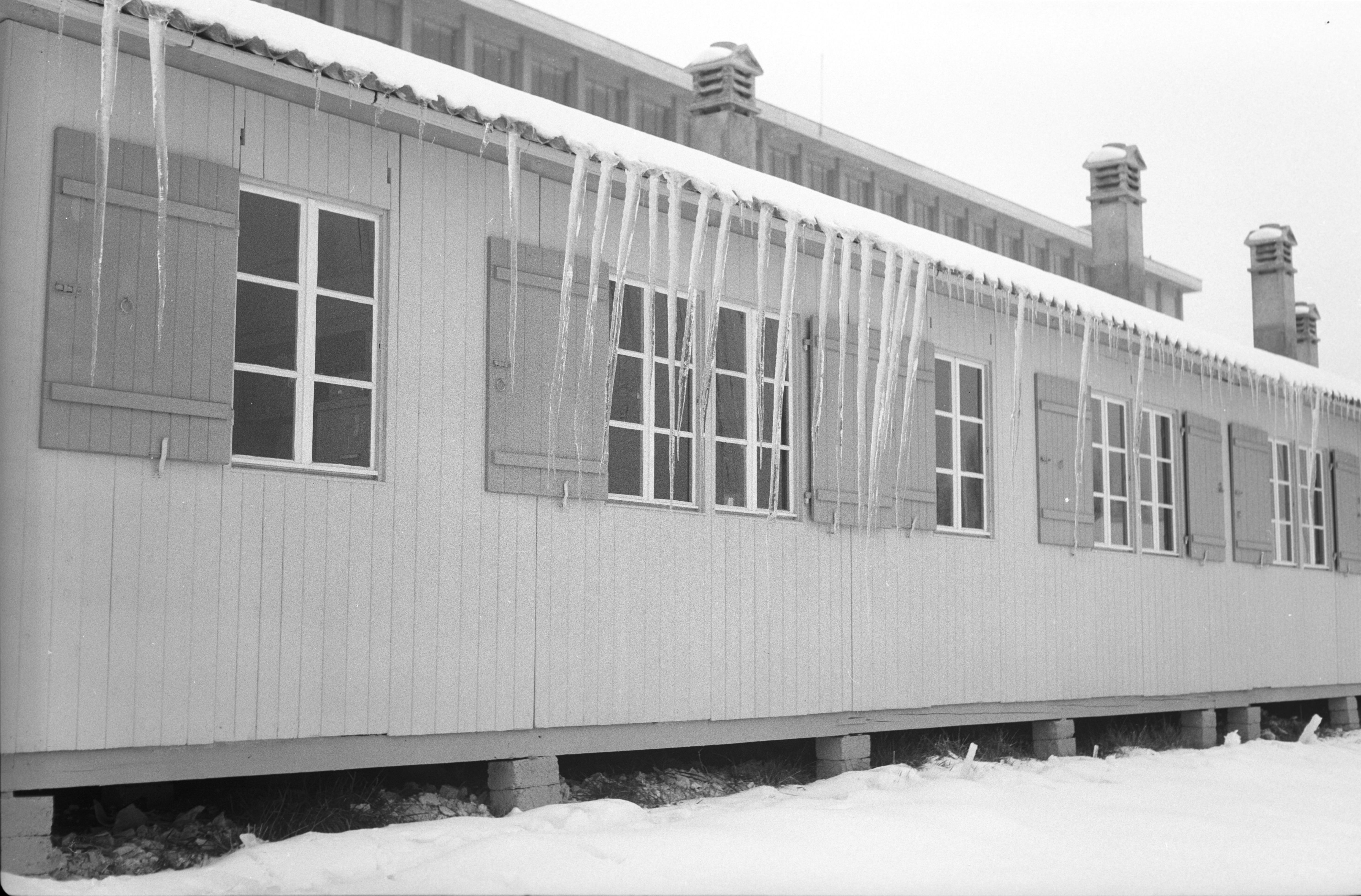 Icicles hang from the barracks next to Geneva airport in December 1954