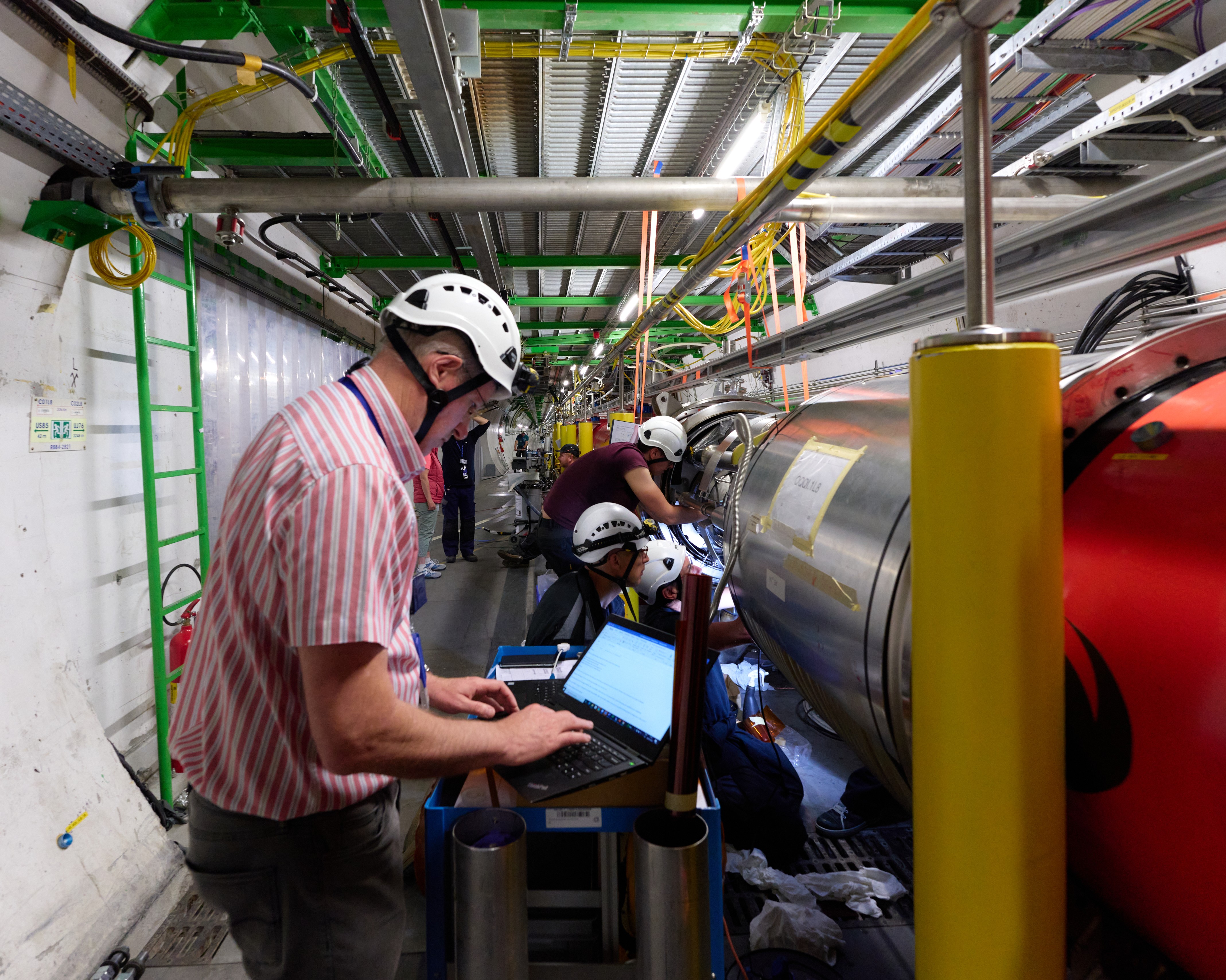 Paul Cruikshank, chef de l'équipe d'intervention sur le vide du LHC, avec son équipe, en train de démarrer le test de fuite sur le soufflet nouvellement installé.